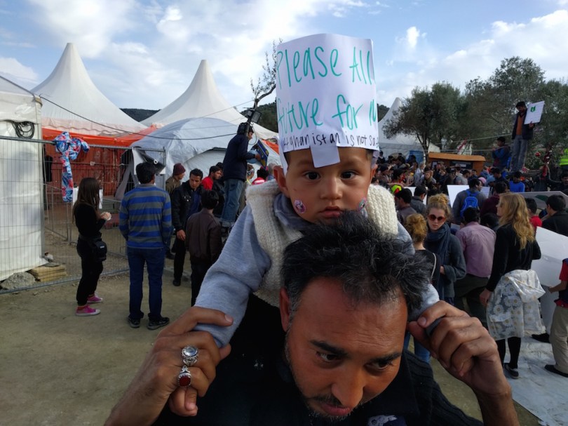 An Afghan child joins a protest at Moria